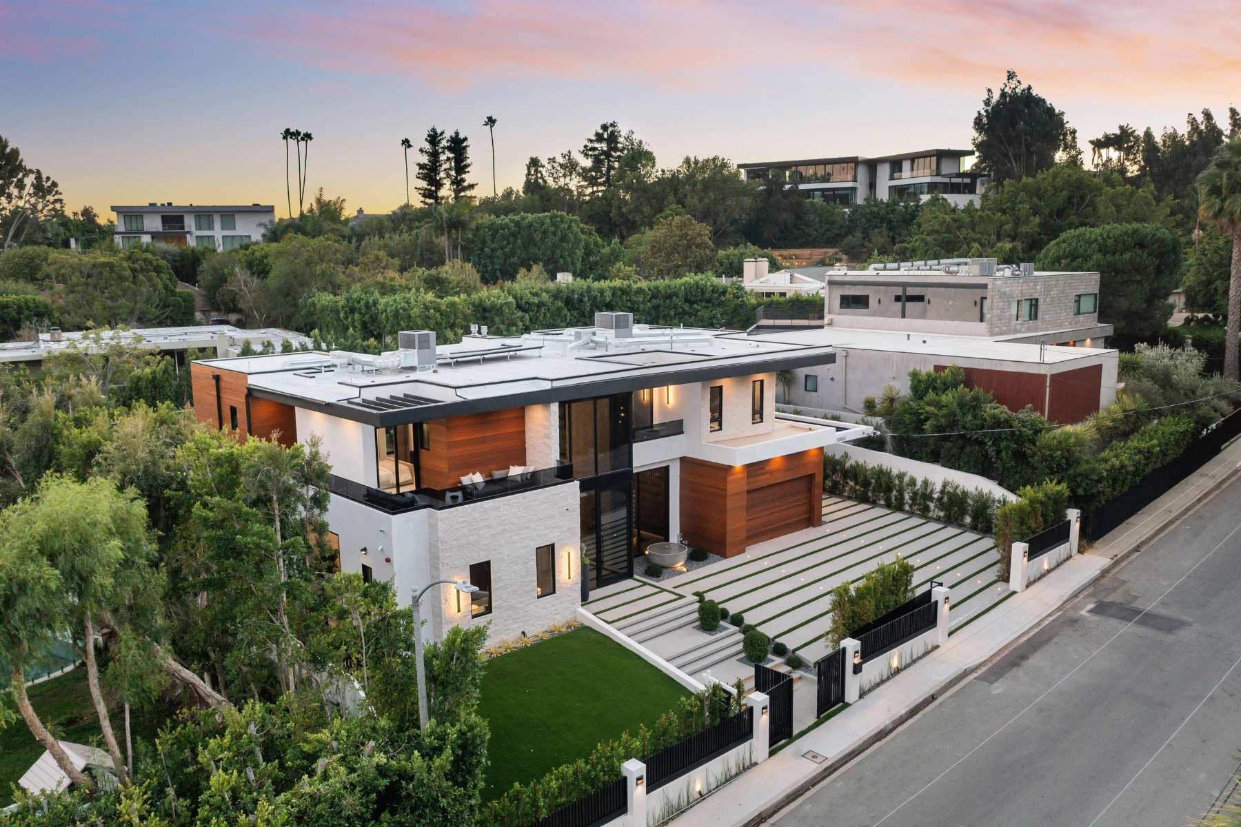 Aerial view of a modern luxury house with landscaped garden at sunset