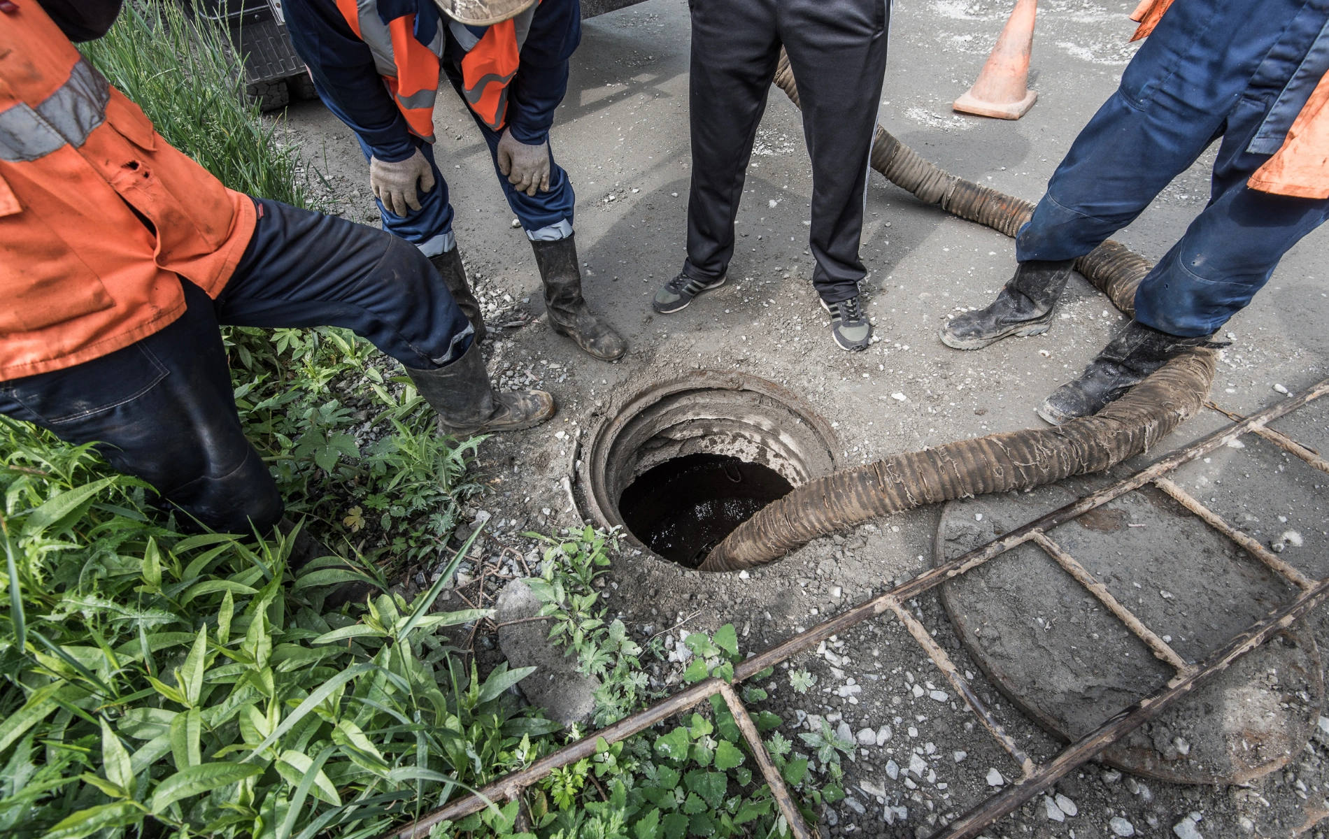 Workers pumping water from a sewerage trench