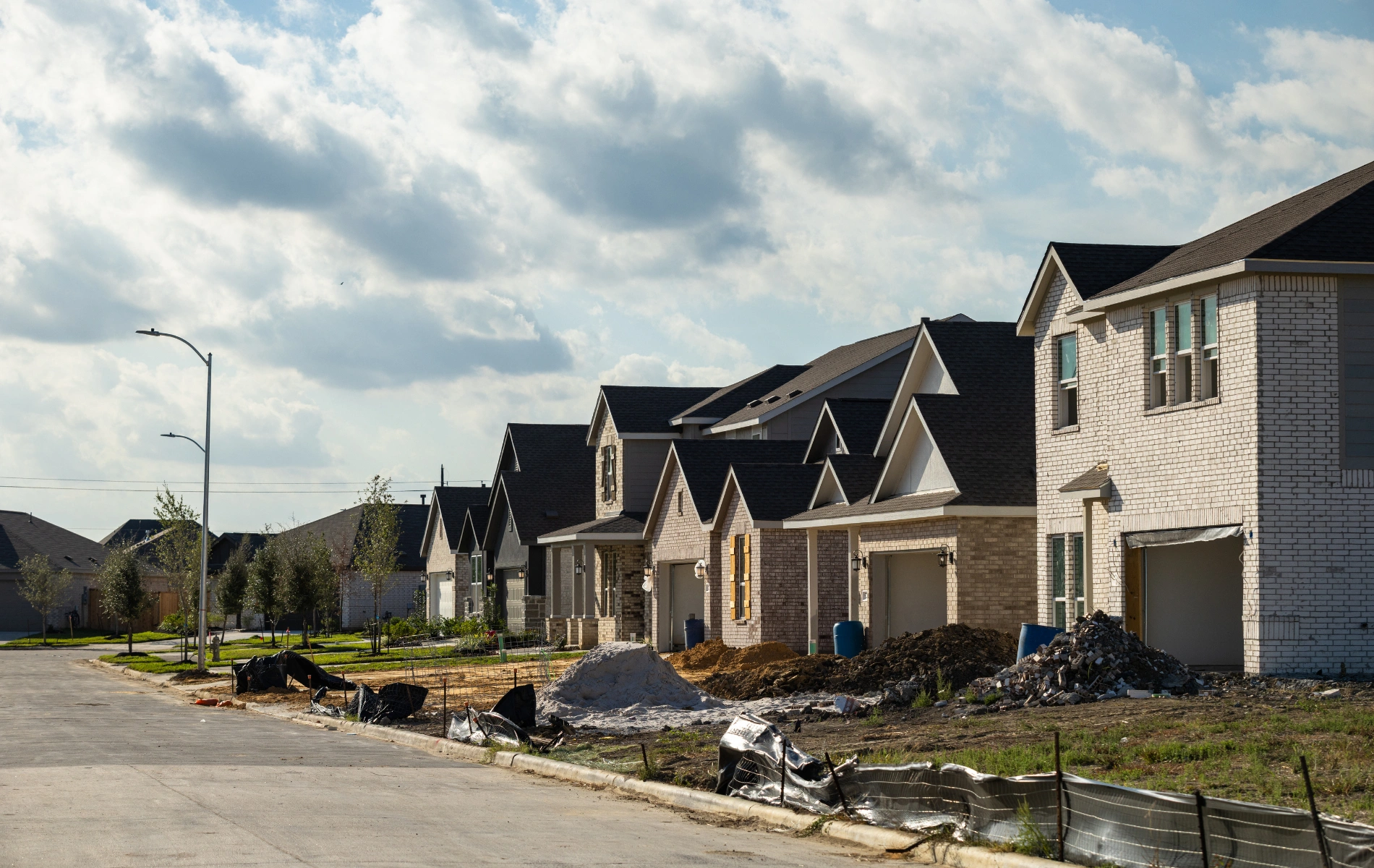 Suburban street with houses under construction in a subdivision